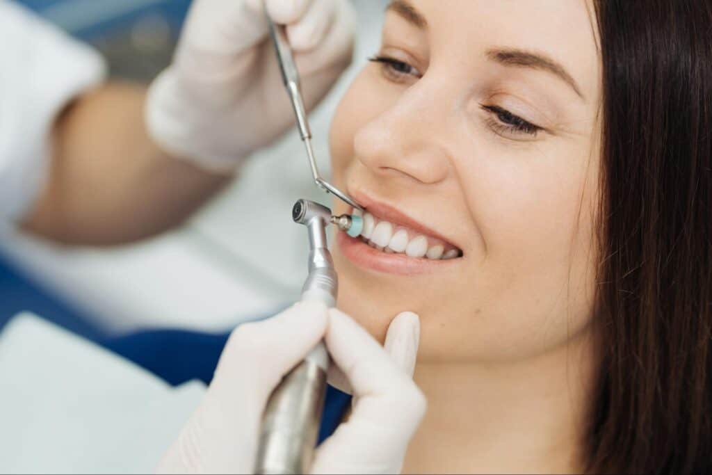 Young woman at dentist chair during a dental scaling procedure