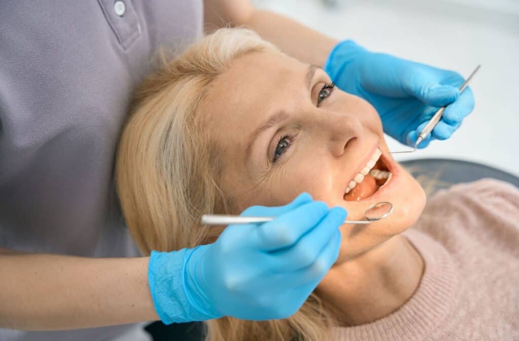 A woman getting her dental bridge examined to see if she needs a replacement