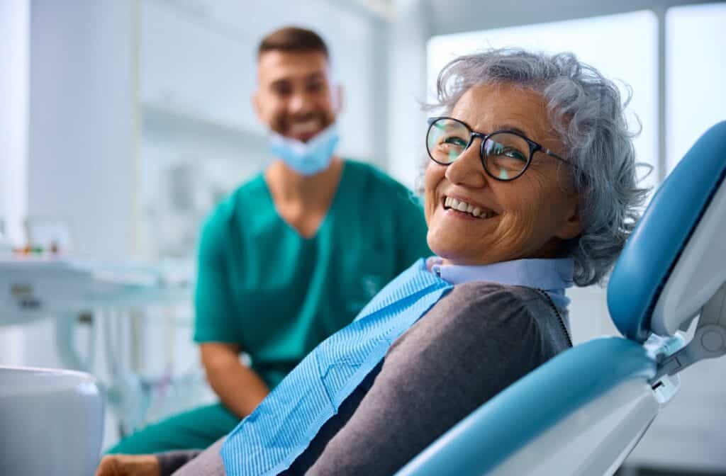 A smiling patient leaning back in their chair during a dental exam.